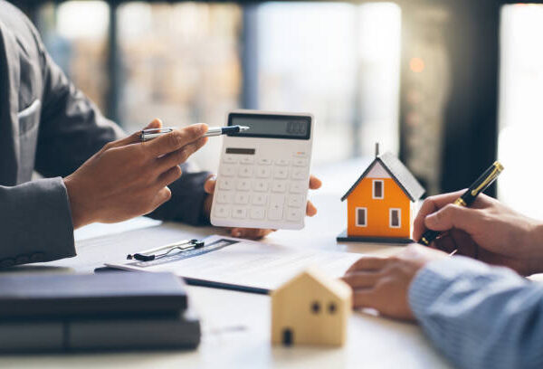 House model with agent and customer discussing for contract to buy, get insurance or loan real estate or property.